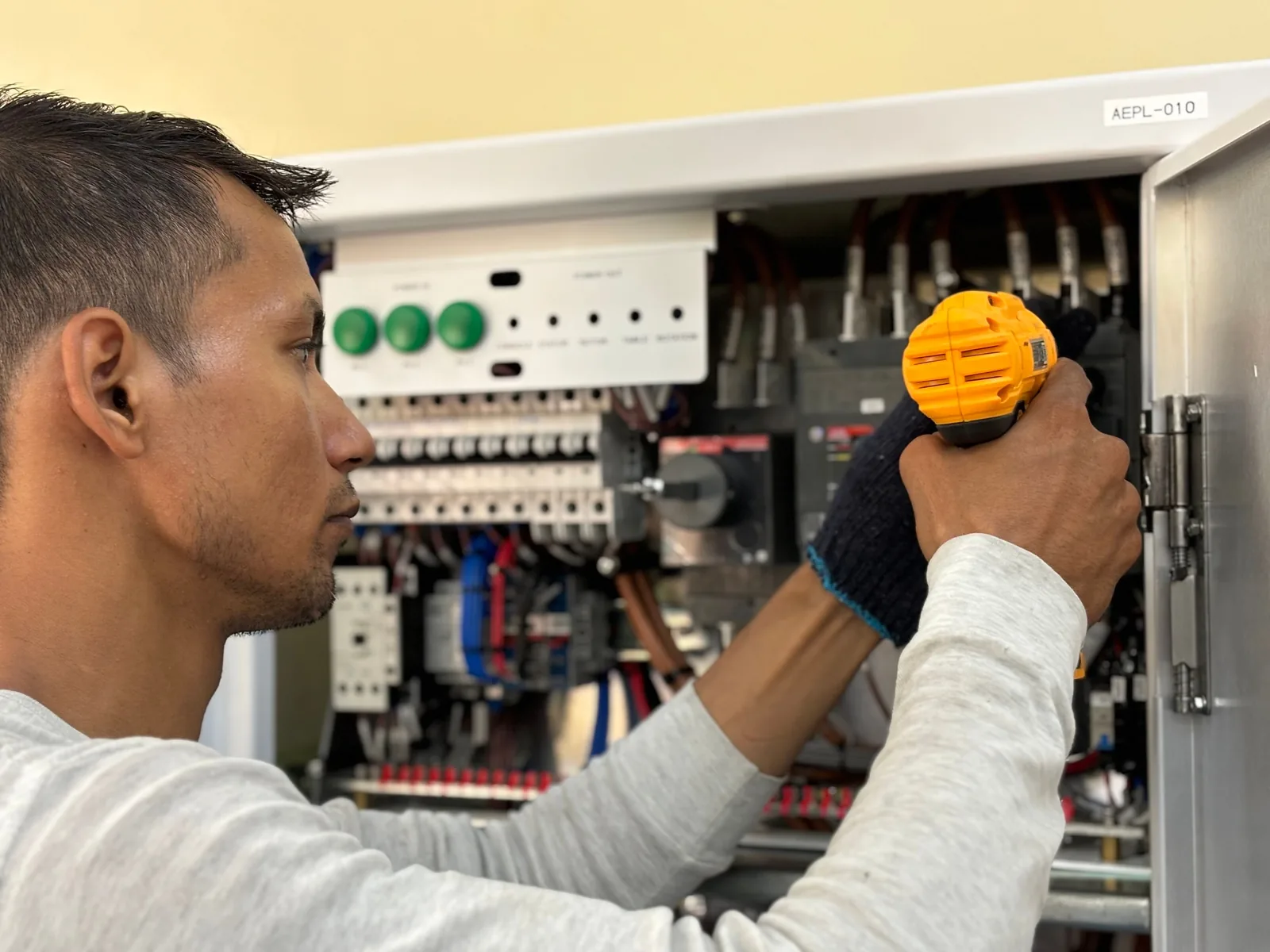 An electrician working on a commercial control panel, for panel upgrade in London