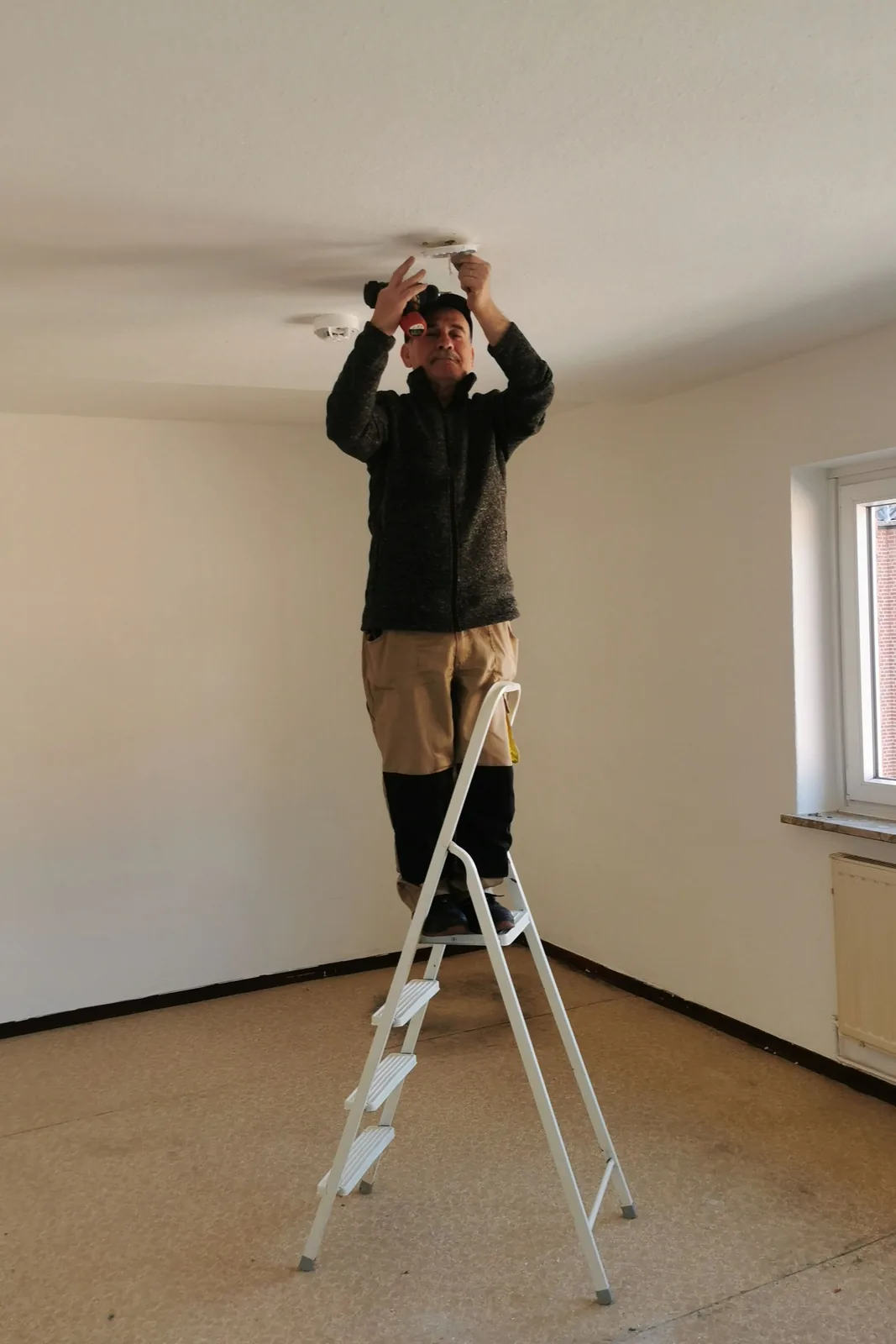 Fitting a ceiling detector from a step ladder, for ceiling fan installation in London